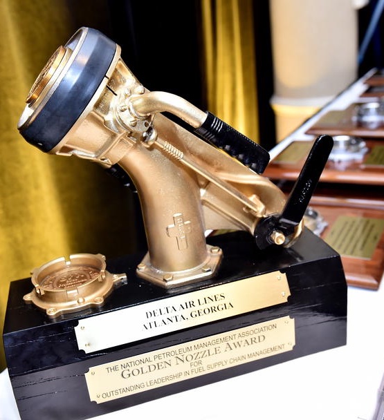 An image of the NPMC Golden Nozzle Award with additional award plaques displayed in the background